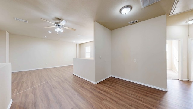 unfurnished room with a textured ceiling, hardwood / wood-style flooring, and ceiling fan