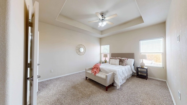 bedroom featuring a tray ceiling, ceiling fan, and light colored carpet