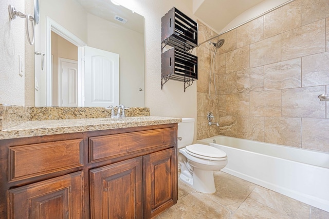 full bathroom featuring vanity, tiled shower / bath combo, and toilet