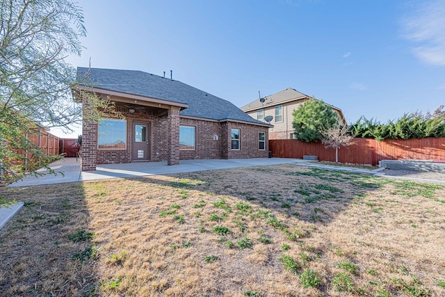 rear view of house featuring a yard, a patio, and ceiling fan