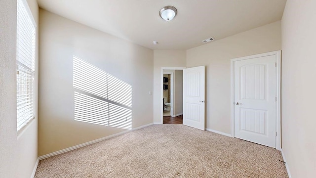 unfurnished bedroom featuring carpet flooring, a closet, and multiple windows