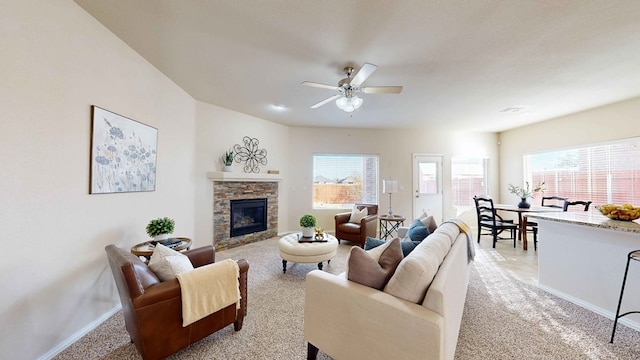 living room featuring ceiling fan, a fireplace, and light carpet