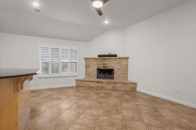 living room with vaulted ceiling, ceiling fan, crown molding, light tile patterned floors, and a stone fireplace