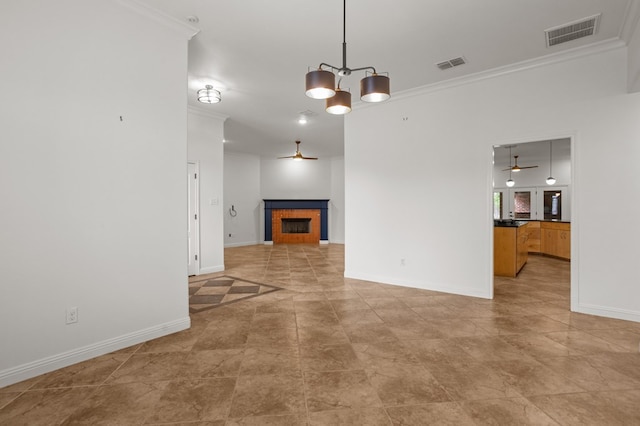 unfurnished living room featuring ceiling fan with notable chandelier and ornamental molding