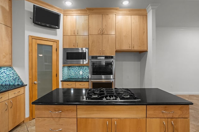 kitchen featuring a center island, dark stone countertops, backsplash, and appliances with stainless steel finishes