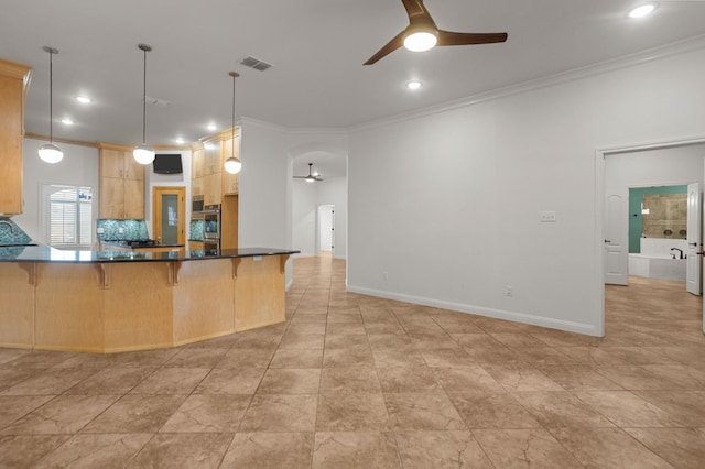 kitchen with a breakfast bar area, light brown cabinets, pendant lighting, and ornamental molding