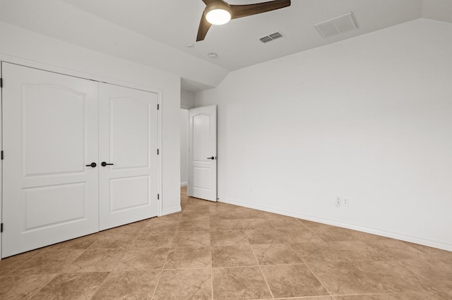 unfurnished bedroom with ceiling fan, vaulted ceiling, and a closet