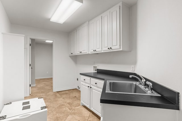 kitchen featuring white cabinets, light tile patterned floors, and sink