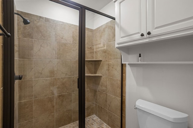 bathroom featuring toilet and a shower with shower door