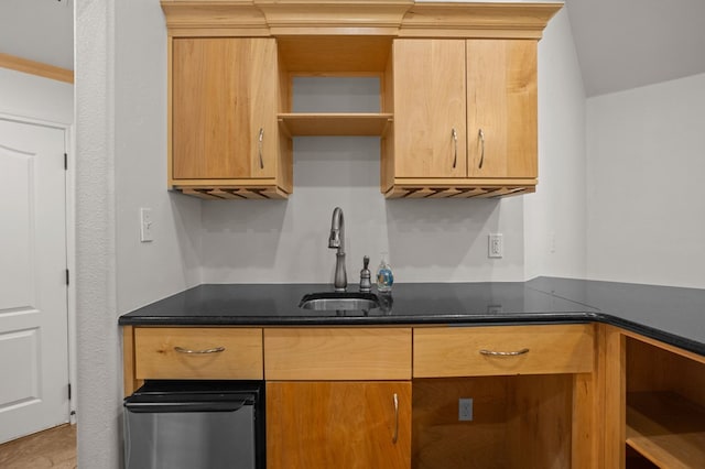 kitchen featuring dark stone counters, ornamental molding, and sink