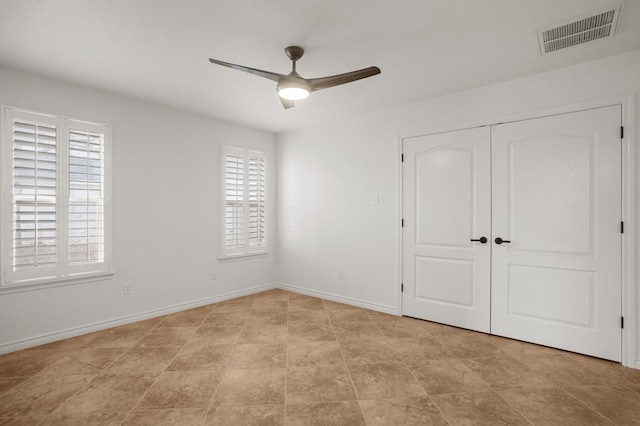 unfurnished bedroom featuring ceiling fan and a closet