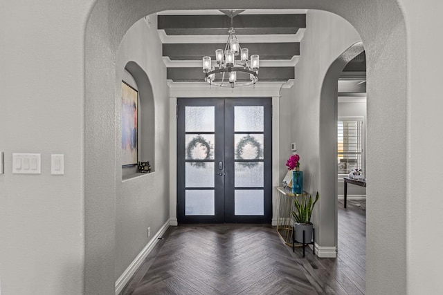 entryway with french doors, dark parquet flooring, and a notable chandelier