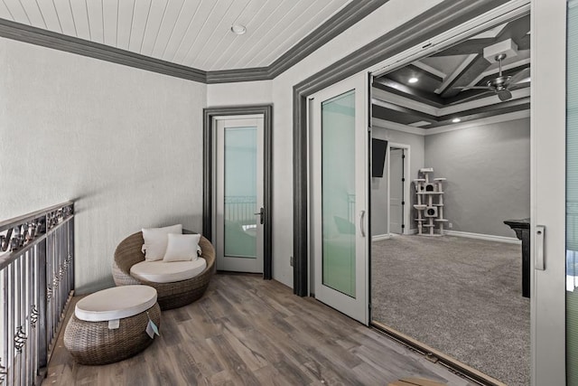 living area featuring coffered ceiling, wood-type flooring, ornamental molding, and ceiling fan