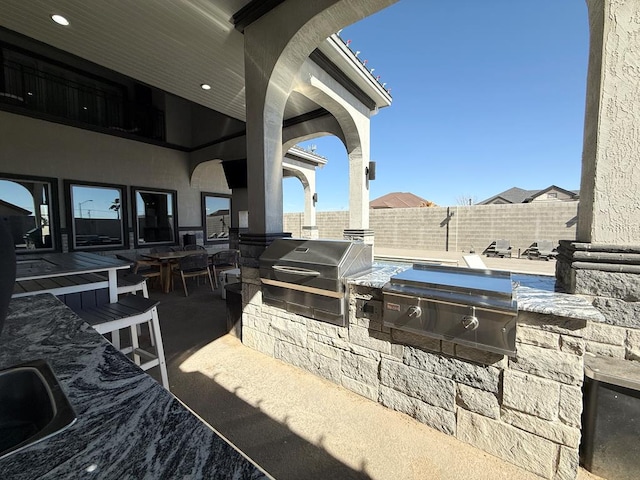 view of patio / terrace with an outdoor kitchen, sink, and grilling area