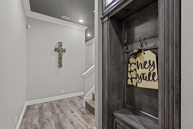 interior space featuring crown molding and light hardwood / wood-style floors