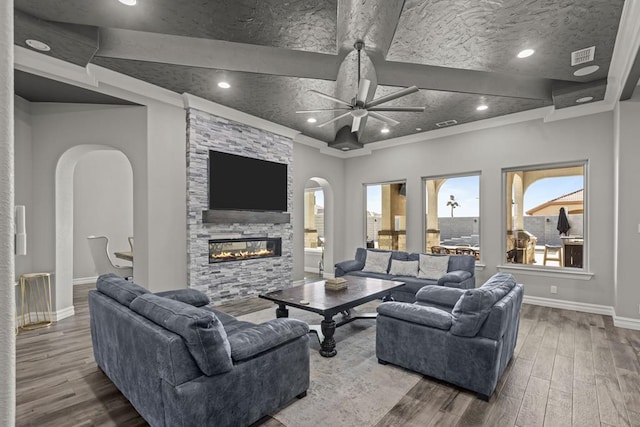 living room with hardwood / wood-style flooring, a fireplace, ornamental molding, and ceiling fan