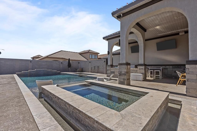 view of pool featuring an in ground hot tub, an outdoor bar, and a patio area