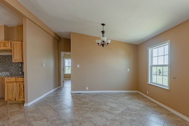 unfurnished dining area featuring an inviting chandelier