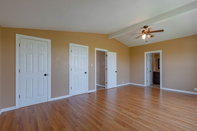 unfurnished bedroom with ensuite bath, ceiling fan, light hardwood / wood-style flooring, and lofted ceiling with beams