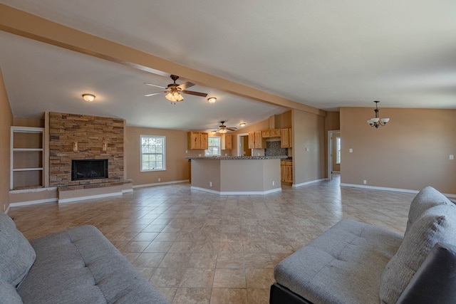 living room featuring vaulted ceiling with beams, a stone fireplace, and ceiling fan with notable chandelier