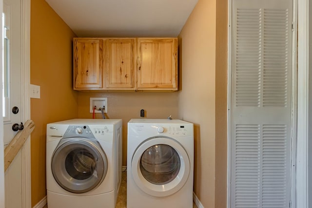 laundry area featuring separate washer and dryer and cabinets