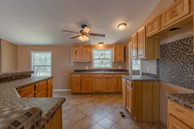 kitchen featuring ceiling fan, sink, and tasteful backsplash