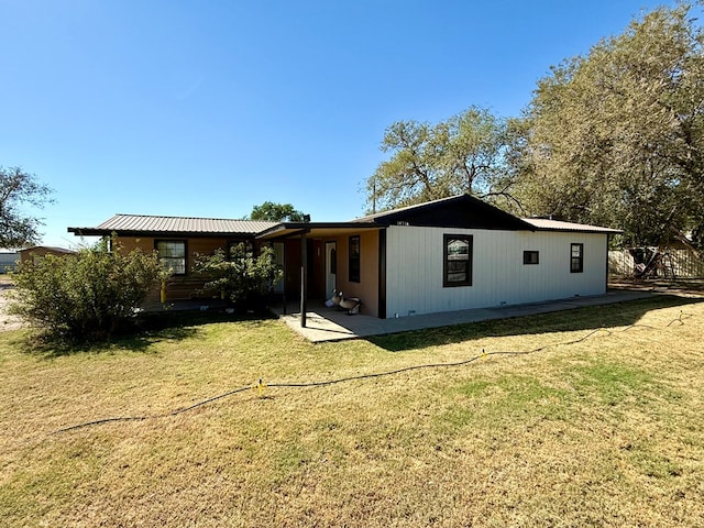 rear view of property featuring a yard and a patio