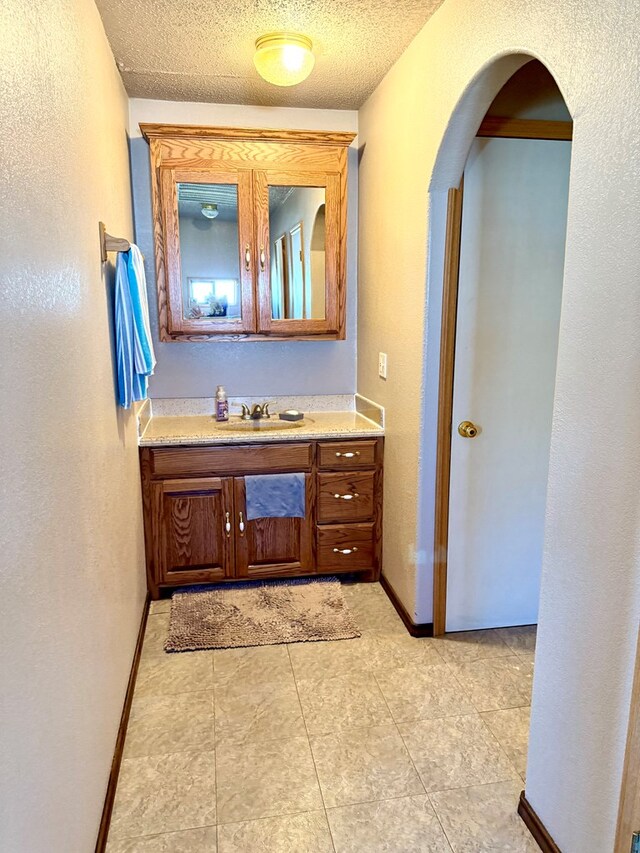 bathroom featuring tile patterned flooring, a textured ceiling, and vanity