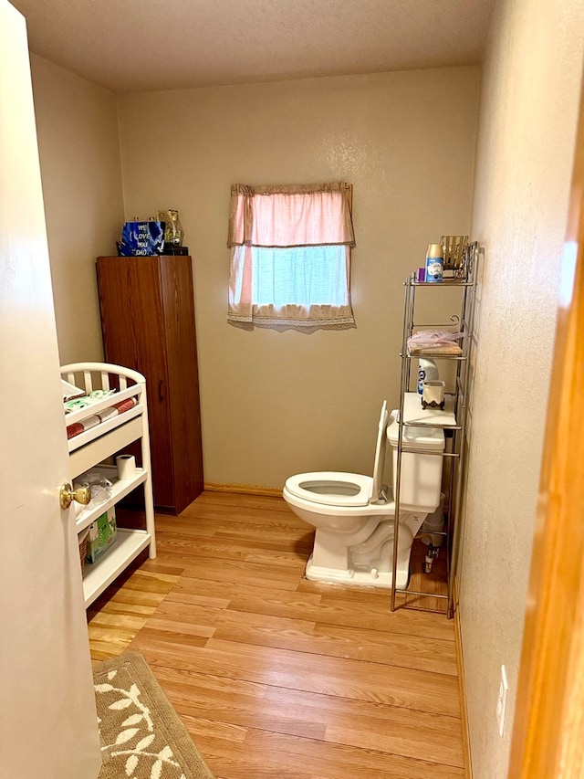 bathroom with toilet and hardwood / wood-style flooring