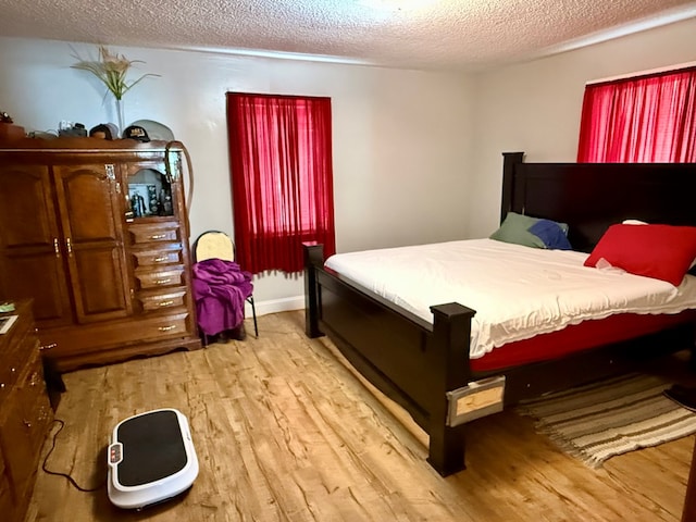 bedroom featuring light hardwood / wood-style flooring and a textured ceiling