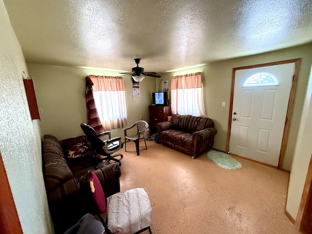 living room with a wealth of natural light, ceiling fan, and a textured ceiling