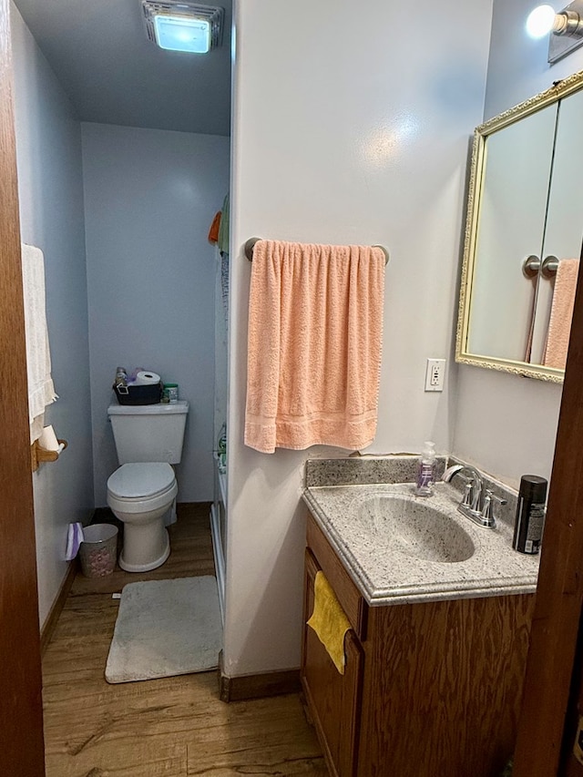 bathroom with vanity, toilet, and wood-type flooring