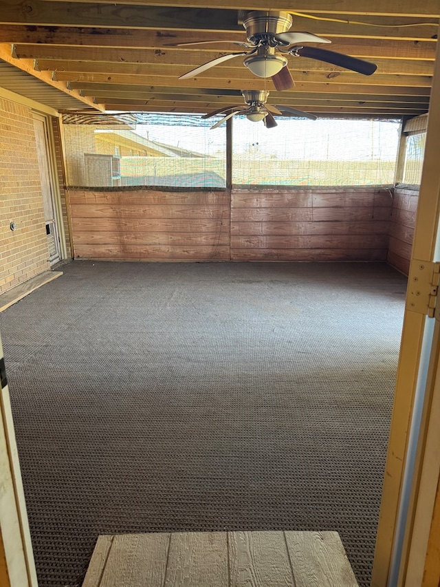 unfurnished sunroom with a ceiling fan