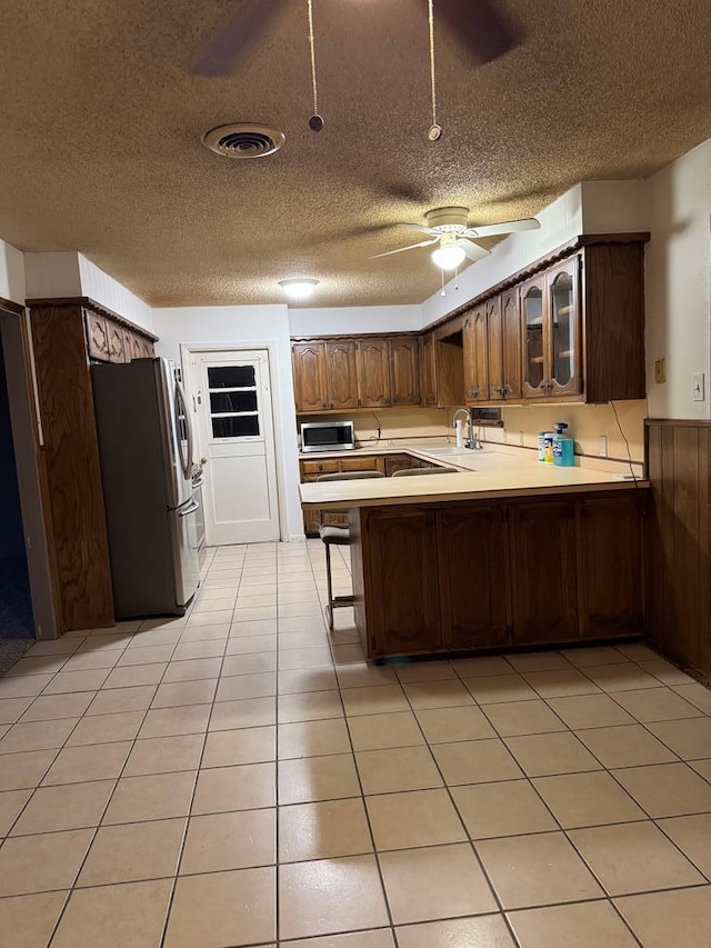 kitchen featuring appliances with stainless steel finishes, visible vents, light countertops, and a peninsula