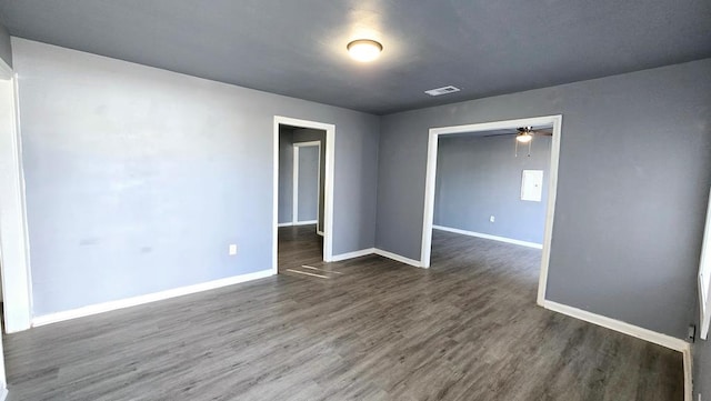 spare room with dark hardwood / wood-style floors and ceiling fan