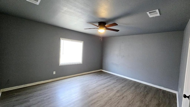 unfurnished room featuring ceiling fan and dark wood-type flooring