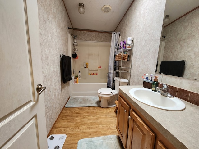 full bathroom featuring vanity, hardwood / wood-style flooring, toilet, ornamental molding, and shower / tub combo