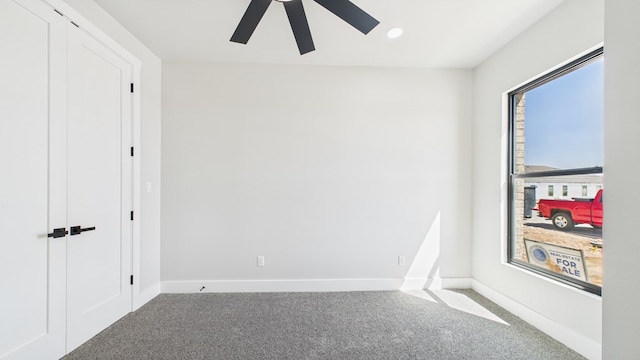 unfurnished room with carpet, a ceiling fan, and baseboards