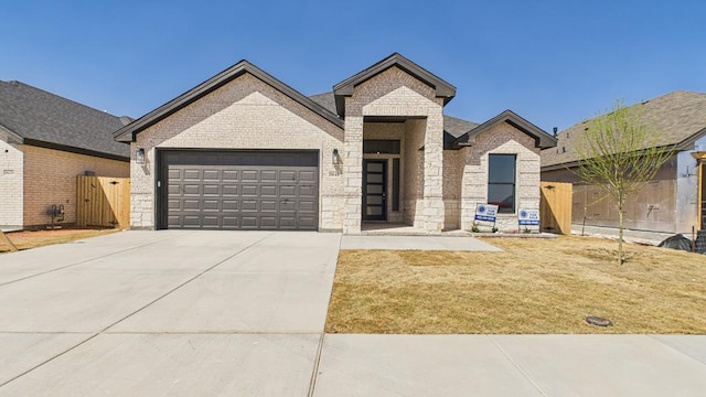 view of front facade with driveway, brick siding, an attached garage, and fence