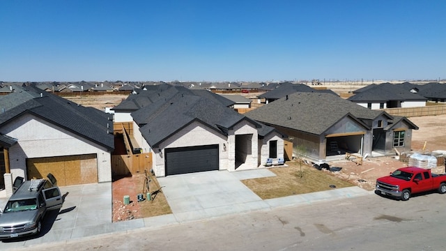 view of front of home featuring a garage, a residential view, and concrete driveway