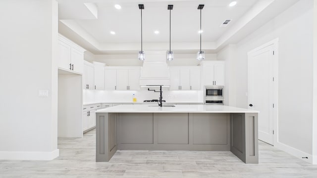 kitchen with stainless steel appliances, a raised ceiling, light countertops, and decorative backsplash