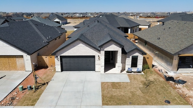 view of front of home featuring an attached garage, a residential view, concrete driveway, and roof with shingles