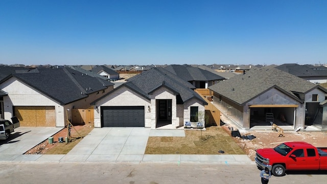 view of front of house featuring a residential view, concrete driveway, roof with shingles, and an attached garage