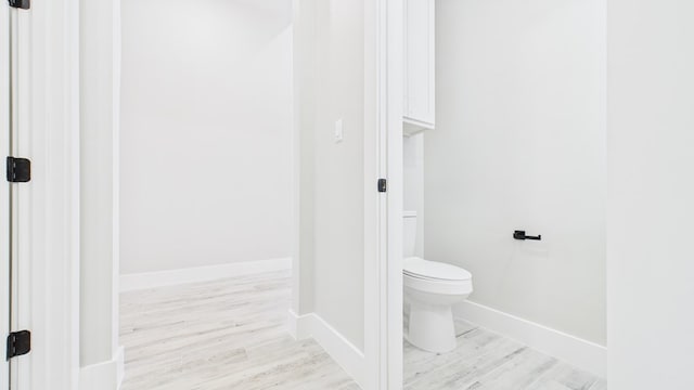 bathroom featuring wood finished floors, toilet, and baseboards