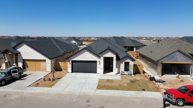 view of front of home featuring roof with shingles, an attached garage, a residential view, stone siding, and driveway