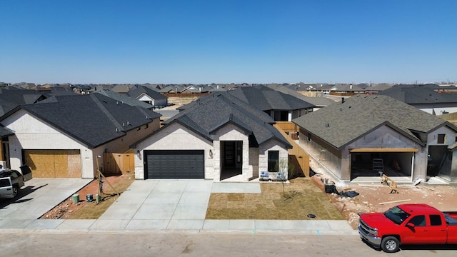 view of front facade with a garage, a residential view, concrete driveway, and roof with shingles