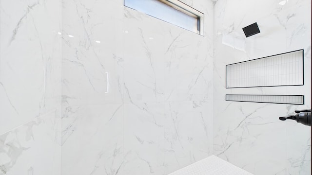 bathroom featuring a marble finish shower