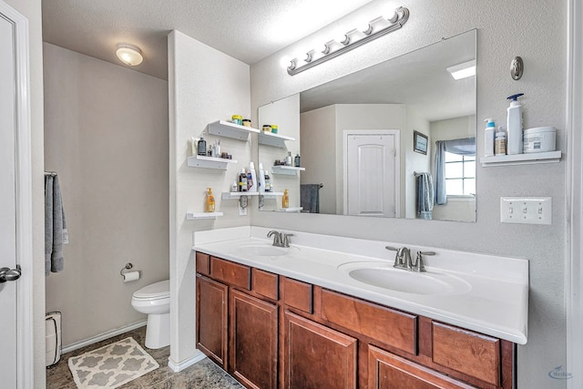 bathroom with vanity, toilet, and a textured ceiling