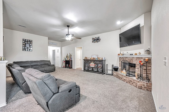 living room with ceiling fan, carpet, and a brick fireplace