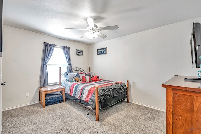 carpeted bedroom featuring ceiling fan and a textured ceiling